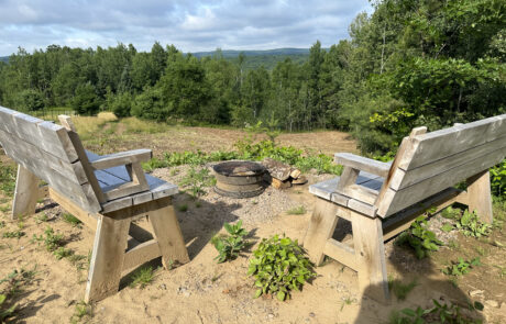benches:fire pit with log cabin view