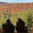 2 women in chairs overlooking a colourful autumn view of the hillside at Rise Above Guest House